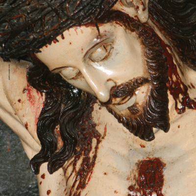 Sul manifesto il volto del Cristo Crocifisso di Frate Innocenzo da Petralia, scultura lignea secentesca custodita nella Chiesa Arcipretale di Santa Barbara in Taverna (CZ).